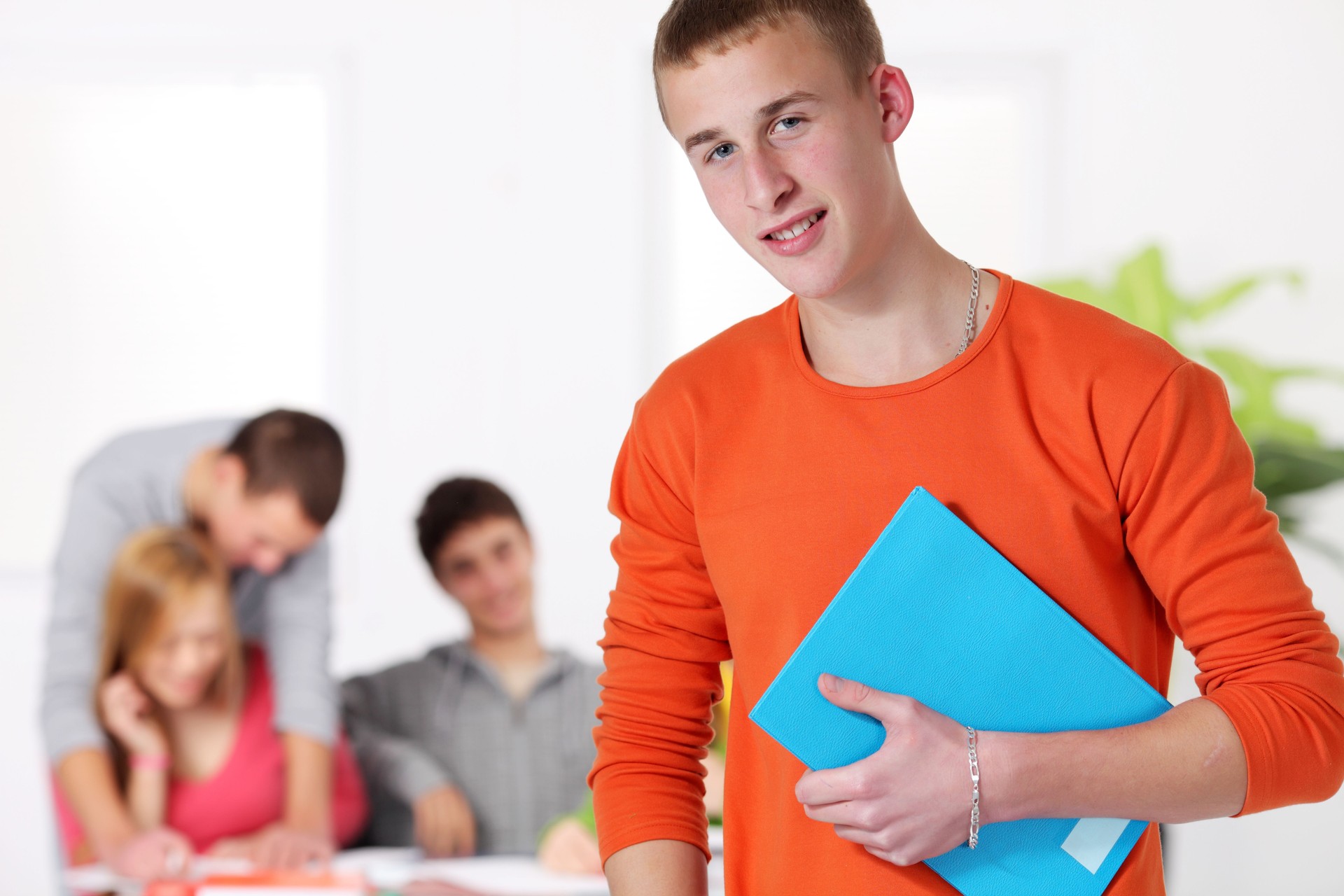 Smiling teenage standing in classroom.